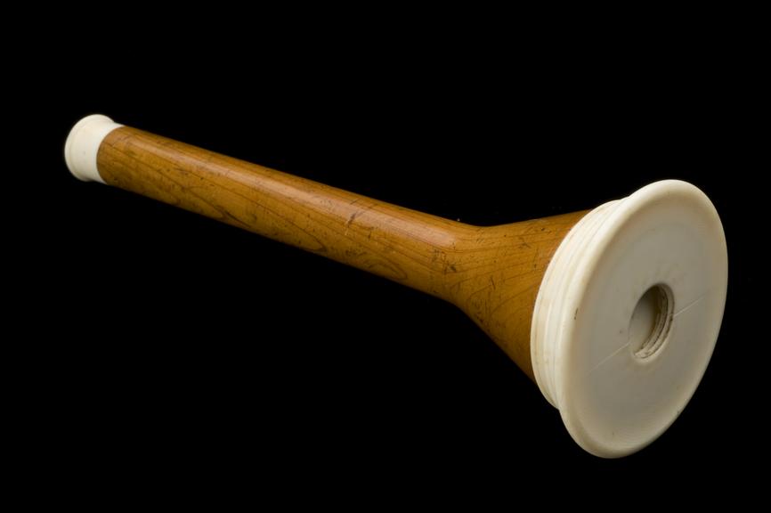 Piorry type monaural stethoscope. Full view, black background.